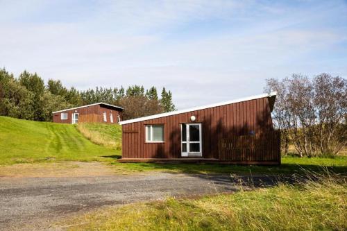 ein kleines Holzgebäude auf einem grasbewachsenen Hügel in der Unterkunft Skálholt Cottages in Selfoss