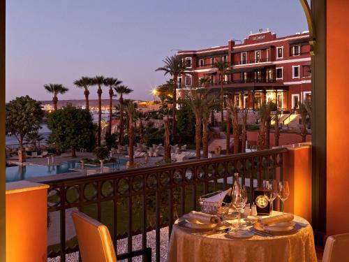 einen Tisch auf dem Balkon mit Blick auf das Resort in der Unterkunft Sofitel Legend Old Cataract in Assuan