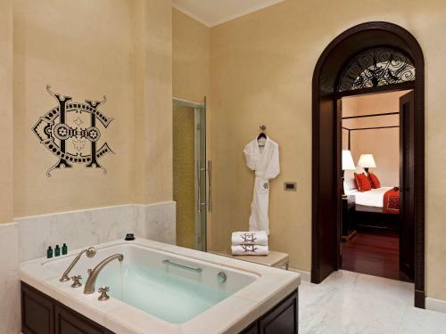 
a bathroom with a tub, sink, mirror and bathtub at Sofitel Legend Old Cataract in Aswan
