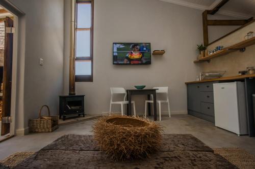 a living room with a tv on the wall at A Hilltop Country Retreat in Swellendam