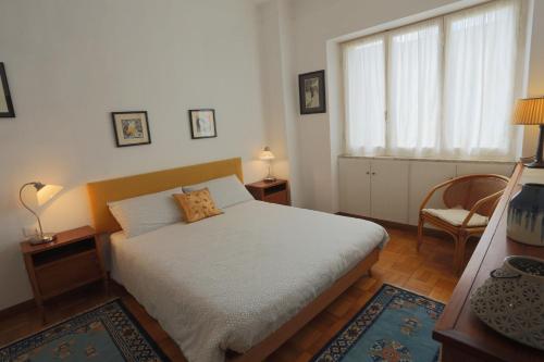 ein Schlafzimmer mit einem Bett, einem Stuhl und einem Fenster in der Unterkunft La Piccola Florida in Sanremo