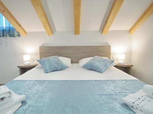 1 dormitorio con 1 cama grande con almohadas azules en Apartments Sweet Escape, en Dubrovnik
