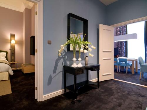 a hotel room with a table with flowers on it at Sofitel Legend The Grand Amsterdam in Amsterdam