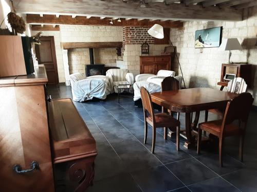 un salon avec une table et une salle à manger dans l'établissement La grange de Fermont, à Capelle-Fermont