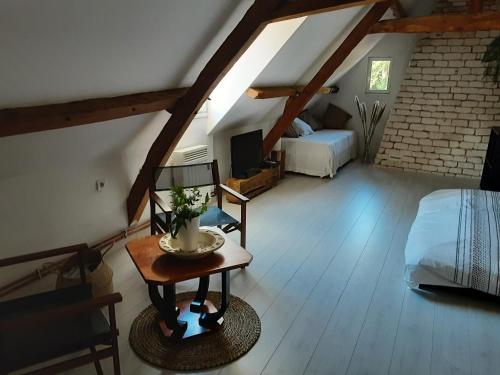 a attic room with a bedroom and a bed and a table at La grange de Fermont in Capelle-Fermont