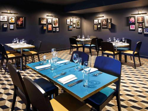 فندق ميركيور إدنبرة سيتي - برينسز ستريت في إدنبرة: غرفة طعام مع طاولات وكراسي وصور على الجدران