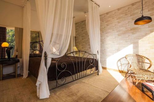 a bedroom with a black bed and a chair at Vila Spa Douro Piscina e acesso privado rio Douro in São Lourenço do Douro