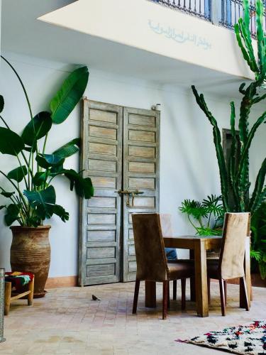 a dining room with a table and some plants at Riad De Vinci & SPA in Marrakech