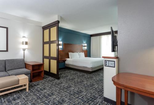 una habitación de hotel con una cama y un sofá en Hyatt Place Columbus-North, en Columbus