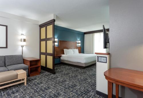 a hotel room with a bed and a couch at Hyatt Place Columbus-North in Columbus