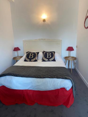 a bedroom with a bed with two pillows on it at Hôtel La Batisse in Crémieu