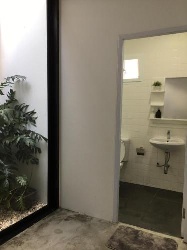 La salle de bains est pourvue de toilettes et d'un lavabo. dans l'établissement เจริญพาณิชย์ รูมส์, à Pathum Thani