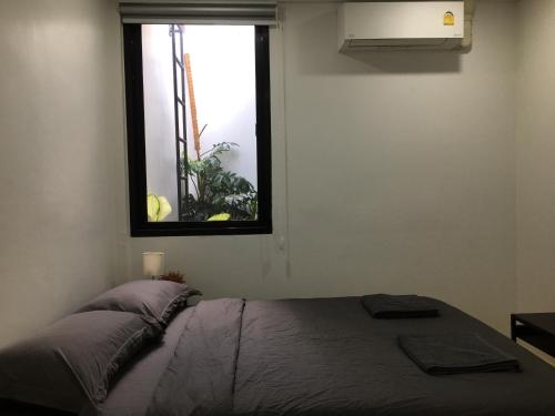 a bedroom with a bed and a window at เจริญพาณิชย์ รูมส์ in Pathum Thani