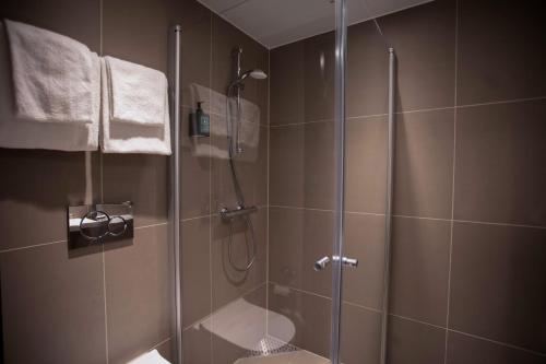 La salle de bains est pourvue d'une douche avec une porte en verre. dans l'établissement Comfort Hotel Bodø, à Bodø