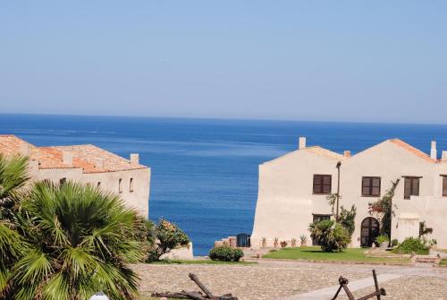 a white house with the ocean in the background at B&B Del Viale in Bacu Abis