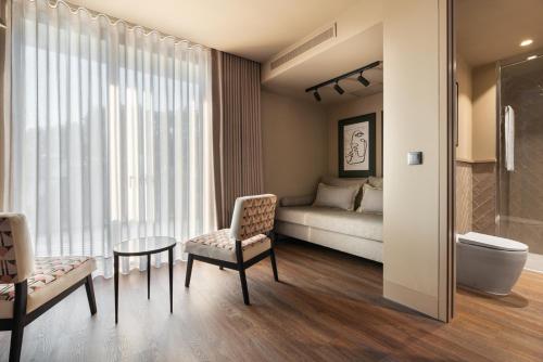 een slaapkamer met een bed, een tafel en een stoel bij Exe Essenzia Porto in Porto