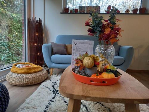 a table with a bowl of fruit and a vase of flowers at B&B Les Lits de Nohaipré in Rendeux