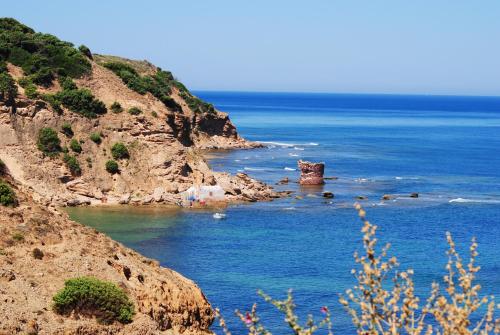 a view of the ocean with a rock in the water at B&B Del Viale in Bacu Abis