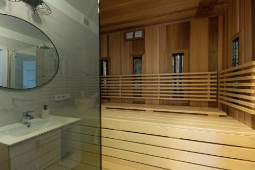 y baño con bañera, lavabo y espejo. en Sun&Sport Apartamenty CEDROWY i ABIES parking i prywatna sauna w cenie, en Szczyrk