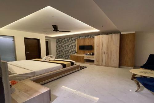 a bedroom with a large bed and a tv at Maps Inn in Ghaziabad