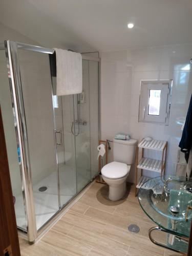 a bathroom with a shower and a toilet and a glass table at Chalet Adosado Urbanización COPOS PREMIUM Zona Media in Sierra Nevada