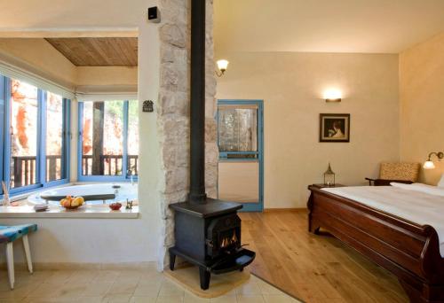 um quarto com uma lareira, uma cama e uma banheira em Darna bagalil Chardonnay suite Perfect for couples em Lavon