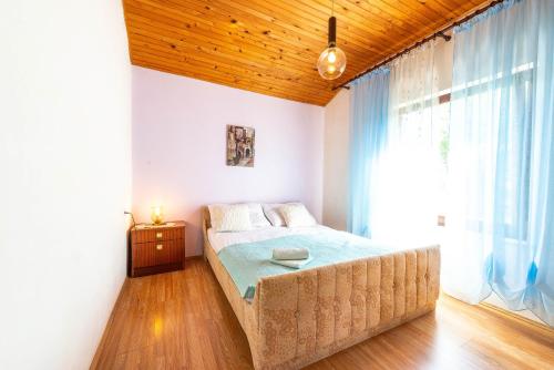 sypialnia z łóżkiem i dużym oknem w obiekcie Apartments Danijela w mieście Stara Novalja