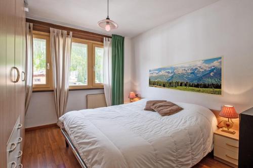 a bedroom with a bed and a painting on the wall at Apartment center Madonna di Campiglio EM in Madonna di Campiglio