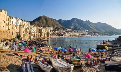 a group of people on a beach with umbrellas at B&B Pepito in Cefalù