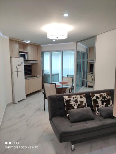 a living room with a couch and a table in it at Residencial Estanconfort Santos in Santos