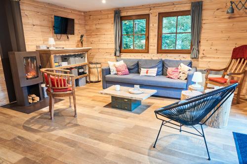 ein Wohnzimmer mit einem blauen Sofa und Holzwänden in der Unterkunft le nid des Mésanges in Büllingen