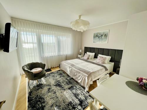 a bedroom with a bed and a chair in it at Villa Dzika Plaża in Gdańsk