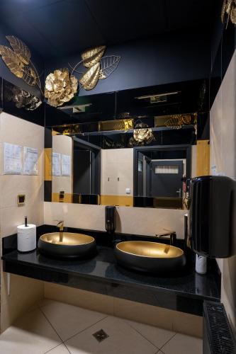 a bathroom with two sinks on a black counter at Hotel Lord Gorlice in Gorlice