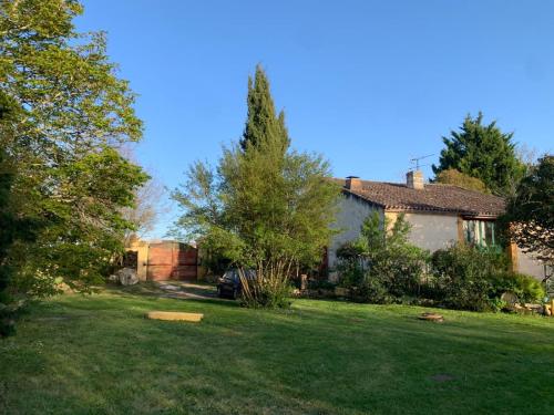 a yard with a house and a tree at Clos Labellie - Gîte et Chambre d'Hôtes à Saint-Emilion in Lugaignac