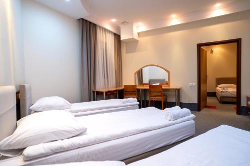 a hotel room with three beds and a table at Hotel Lord Gorlice in Gorlice
