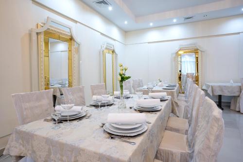 a dining room with a long table with chairs and mirrors at Hotel Lord Gorlice in Gorlice