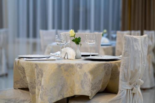 a table with wine glasses and a yellow flower on it at Hotel Lord Gorlice in Gorlice