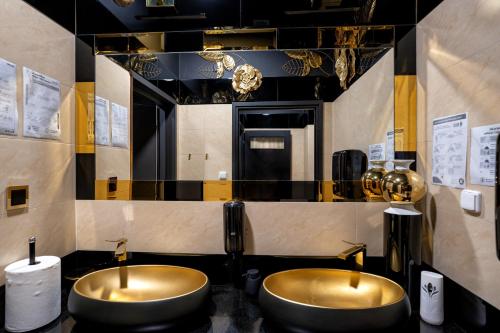 zwei Waschbecken im Bad mit zwei Spiegeln in der Unterkunft Hotel Lord Gorlice in Gorlice