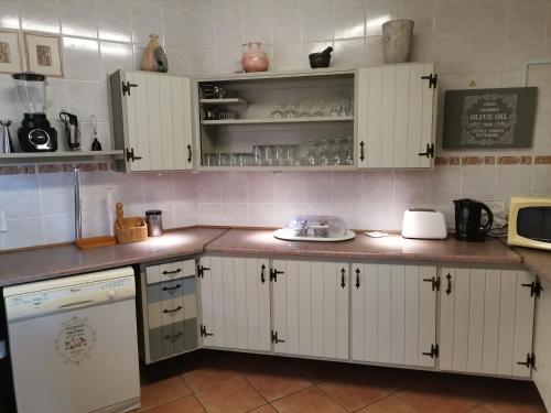 a kitchen with white cabinets and a counter top at Ridgeview Holiday Accommodation in Umzumbe