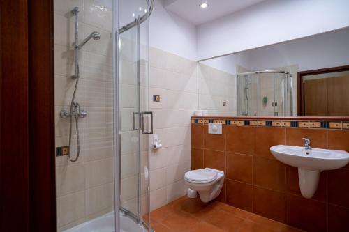 a bathroom with a shower and a toilet and a sink at Hotel Lord Gorlice in Gorlice