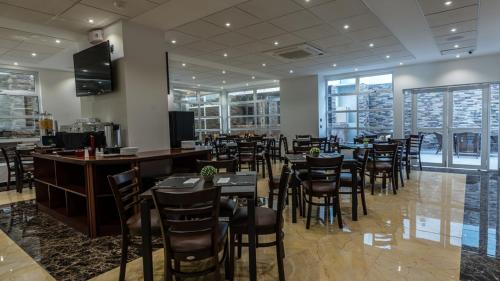 a restaurant with tables and chairs and a bar at Hotel Costa Pacifico - Suite in Antofagasta