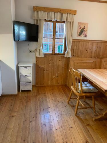 a dining room with a wooden table and a television at Bio-Hof Windhaber in Stubenberg
