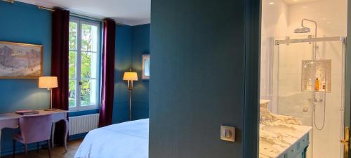 a blue bedroom with a bed and a shower at CHATEAU DE BRINVILLE in Saint-Sauveur-sur-École