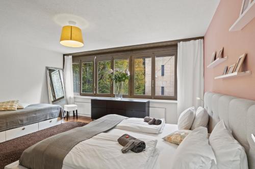 a bedroom with two beds and a large window at Large, central, bright flat in Luzern