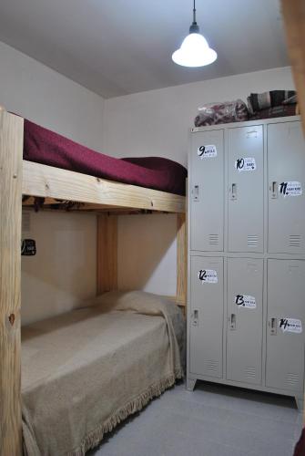 a room with two bunk beds and some cabinets at Ruca Kiñe Hostel in Las Grutas