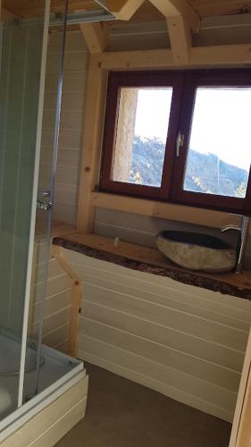 a bathroom with a shower and a sink and a window at Auberge La Coulette in Vars