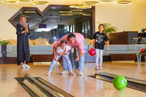 a group of people playing a game of bowling at Bay La Sun Hotel and Marina - Emaar King Abdullah Economic City in King Abdullah Economic City