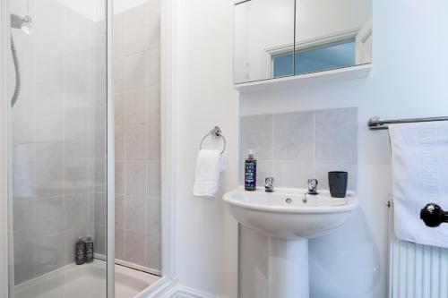 a white bathroom with a sink and a shower at Little Haven in Falmouth
