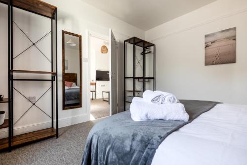 een slaapkamer met een bed en een spiegel bij Little Haven in Falmouth