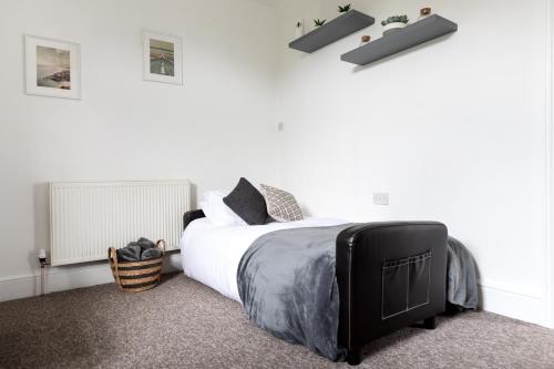 a bedroom with a large bed with white walls at Little Haven in Falmouth